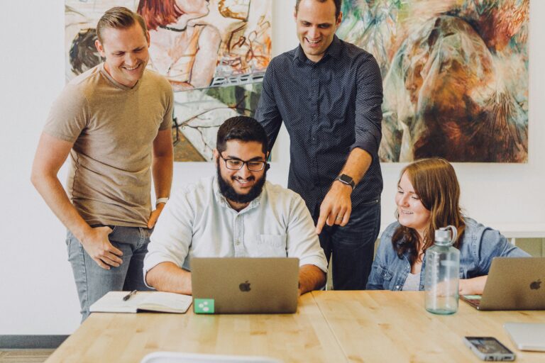 Team collaborating around a laptop during a working session