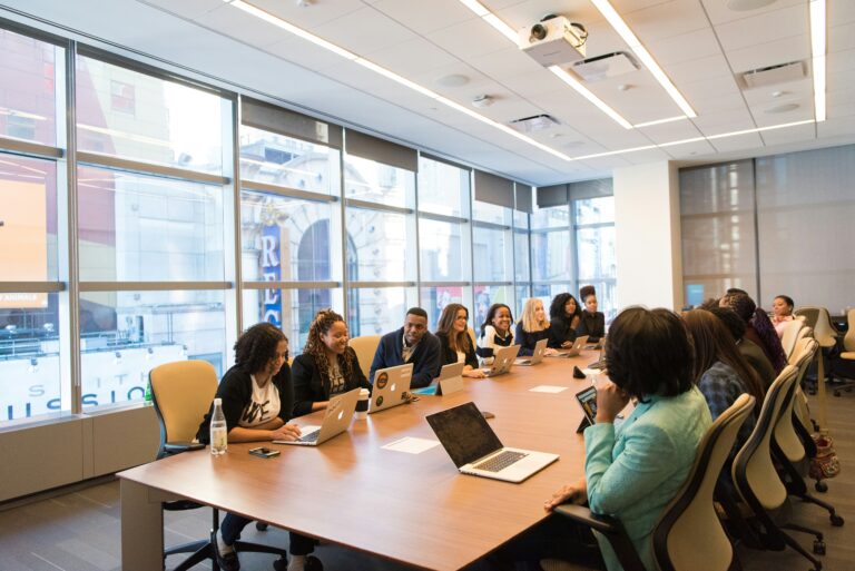Team members gathered around a conference table during a collaborative workplace meeting.